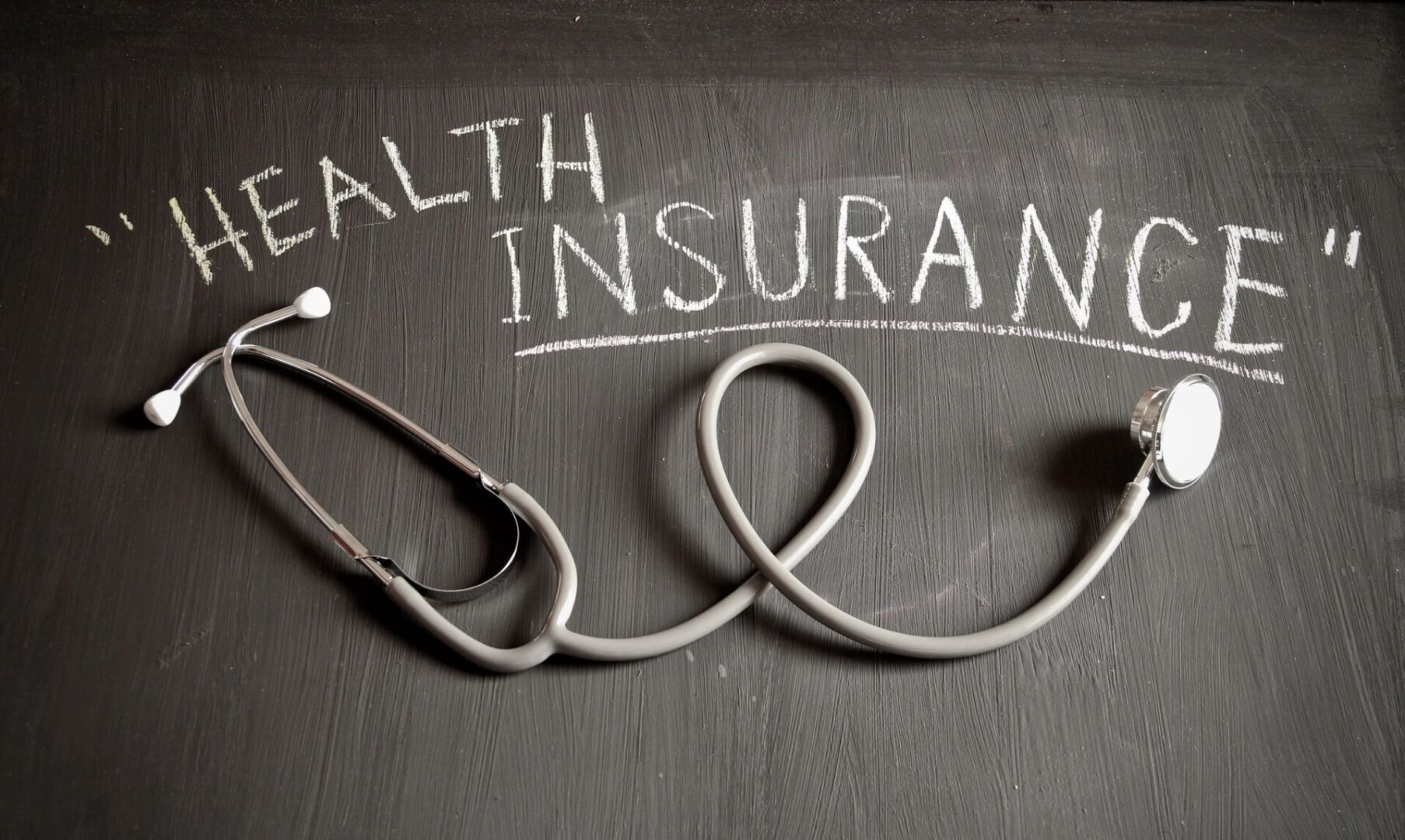 Health Insurance Concept Writing on Blackboard